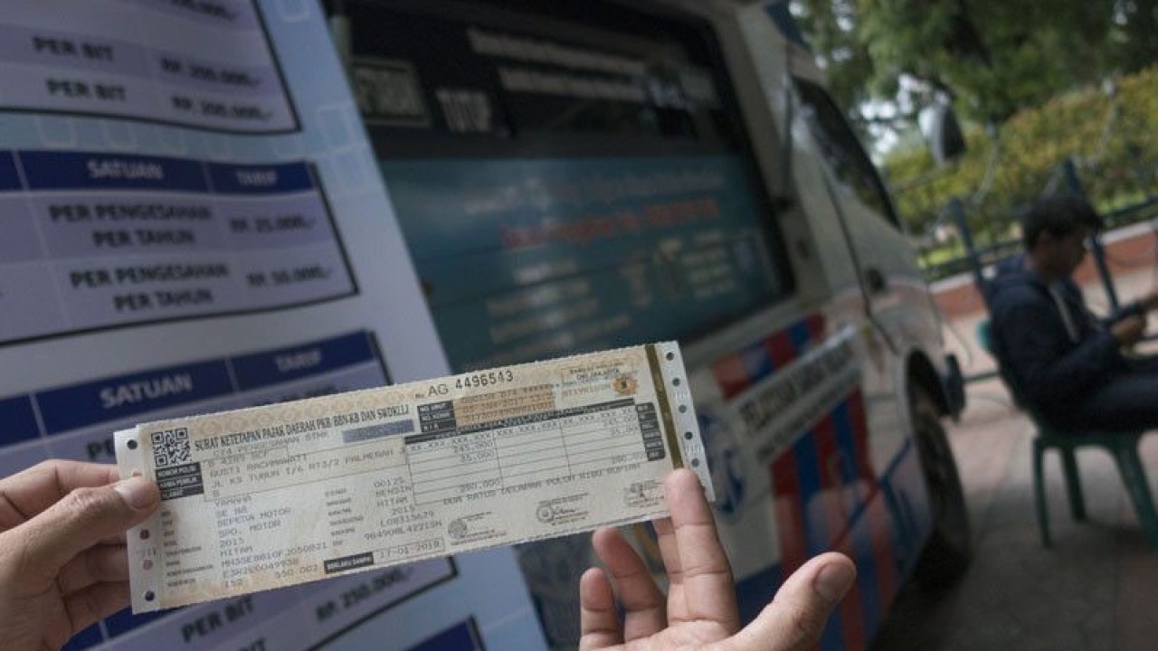 Ilustrasi - Warga menunjukkan STNK yang baru diperpanjang di Samsat Keliling, Jakarta. ANTARA FOTO/Rosa Panggabean/foc/aa.
