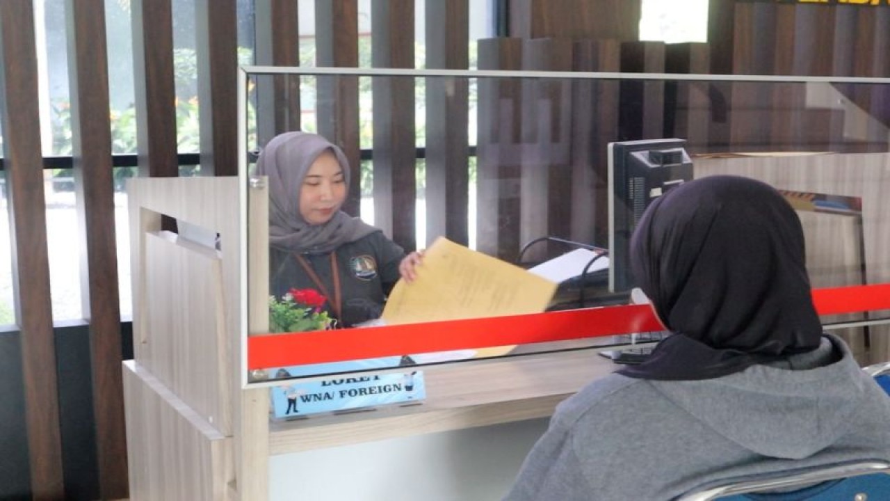 Petugas Kantor Imigrasi Entikong perbatasan Indonesia dan Malaysia, wilayah Sanggau Kalimantan Barat sedang memberikan pelayanan kepada masyarakat dalam pembuatan paspor. ANTARA/HO-Imigrasi Entikong. (Teofilusianto Timotius)