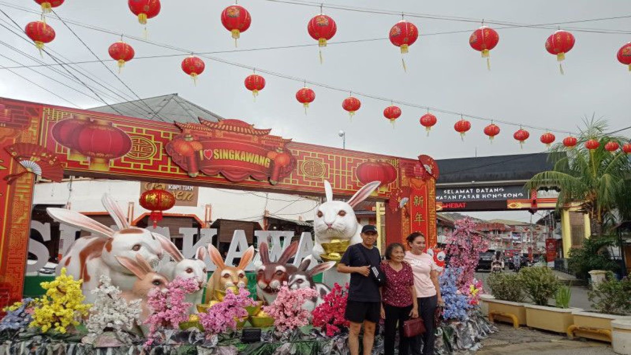 Satu keluarga berfoto di depan Patung Kelinci yang menjadi simbol perayaan Imlek 2574 di Kota Singkawang, Sabtu (21-1-2023). ANTARA/Nurul Hayat