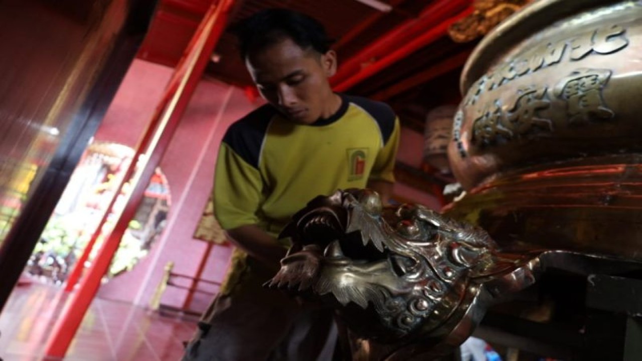 Seorang warga membersihkan sisa kotoran arca yang akan dipersiapkan pada acara Festival Pintu Dalem dalam rangka perayaan Imlek 2023 di Kota Pekalongan, Minggu (29/1/2023). (ANTARA/HO-Humas Kota Pekalongan)