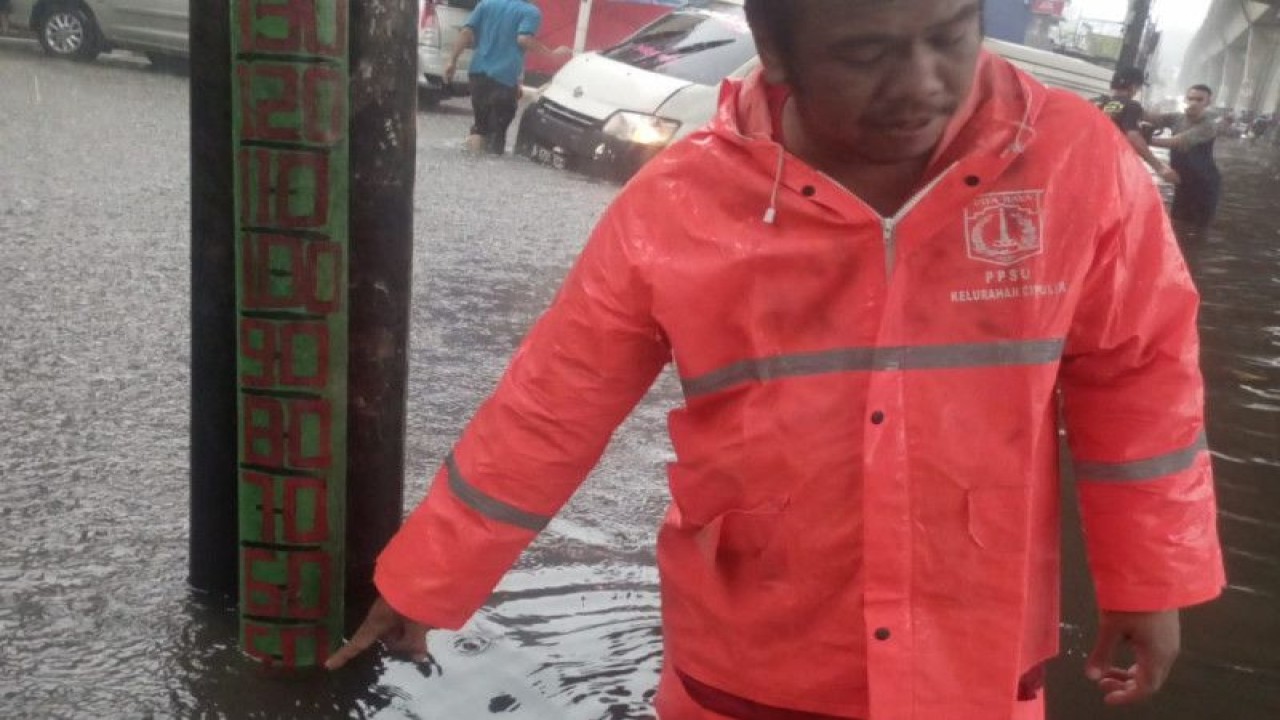 Petugas menunjukkan ketinggian genangan air di salah satu ruas jalan di Cipulir, Jakarta Selatan, Rabu (4/1/2023) ANTARA/HO-BPBD DKI