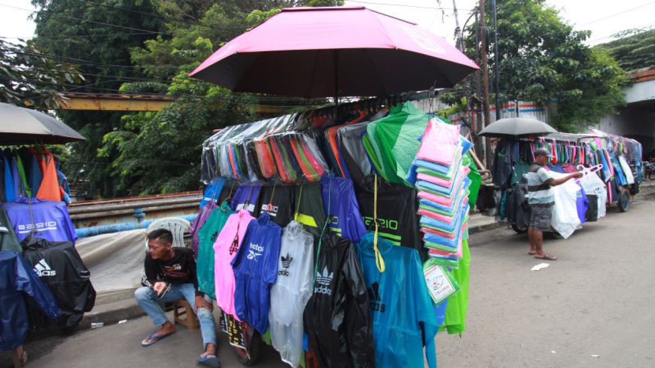 Pedagang jas hujan menunggu calon pembeli di Jalan Matraman, Jakarta, Rabu (4/1/2023). ANTARA FOTO/Reno Esnir/rwa.