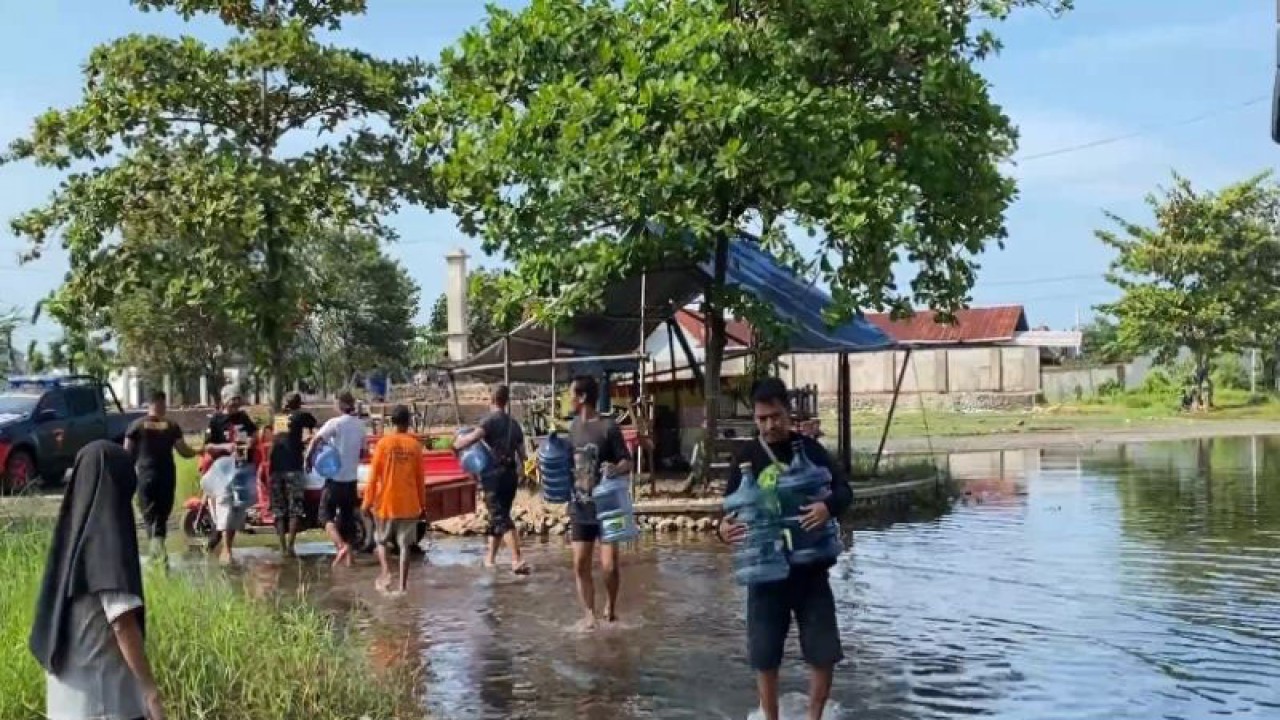 Warga korban banjir di Kota Pekalongan memanfaatkan bantuan air siap minum dari Brimob Polda Jateng, Jumat (6/1/2023). (ANTARA/Kutnadi)