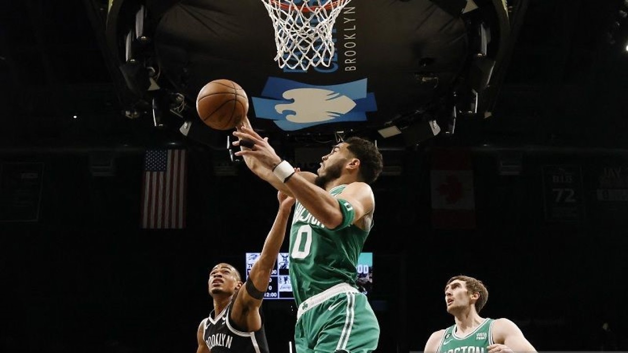 Bintang Boston Celtics Jayson Tatum (tengah) memenangi perebutan bola rebound dengan pemain Brooklyn Nets Nic Claxton (kiri) dalam gim lanjutan NBA di Barclays Center, New York, Amerika Serikat, Kamis (12/1/2023) waktu setempat. (ANTARA/AFP/GETTY IMAGES/Al Bello)