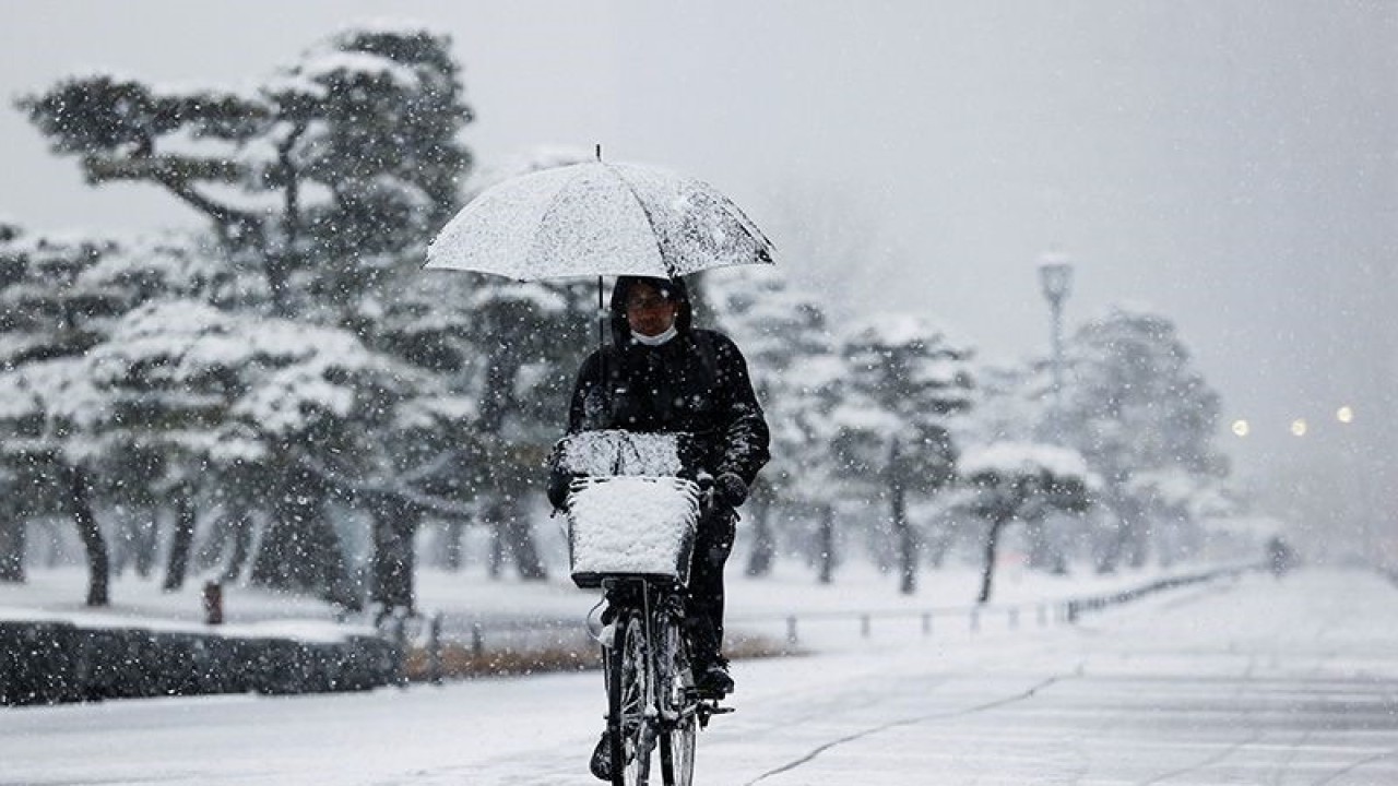Arsip foto - Seorang pria mengendarai sepeda di tengah hujan salju saat pandemi COVID-19, di Tokyo, Jepang (6/1/2022). ANTARA FOTO/REUTERS/Issei Kato/aww/aa. (REUTERS/ISSEI KATO)