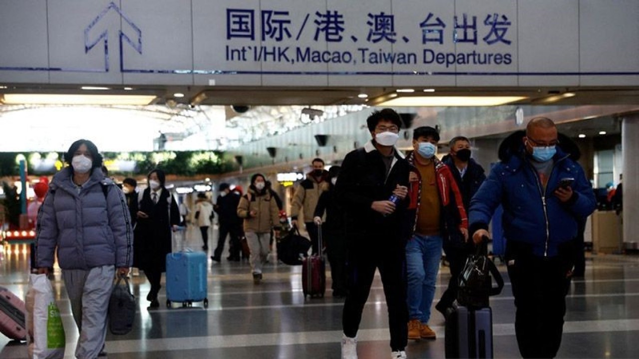 Orang-orang berjalan dengan barang bawaan mereka di Bandara Internasional Ibu Kota Beijing, di tengah wabah COVID-19, di Beijing, China, Selasa (27/12/2022). ANTARA/REUTERS/Tingshu Wang/am.