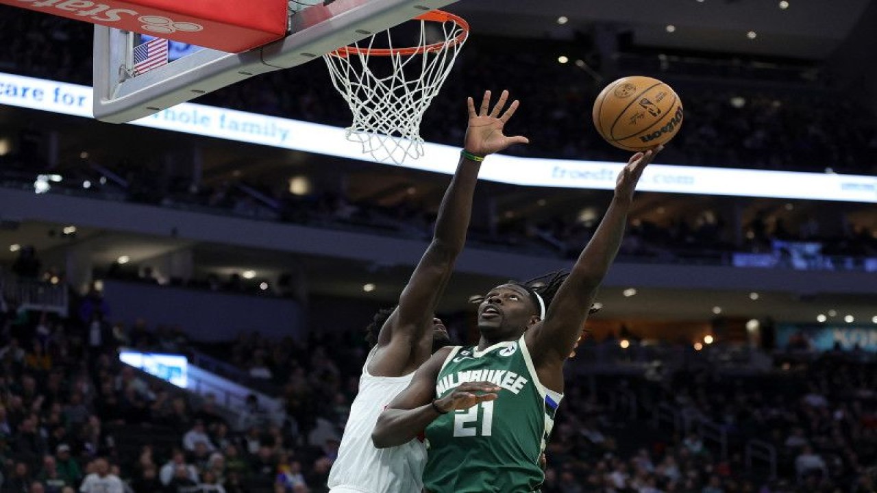 Pebasket Milwaukee Bucks Jrue Holiday (kanan) berupaya memasukkan bola melewati pebasket Toronto Raptorsof O.G. Anunoby saat pertandingan NBA kedua tim di Fiserv Forum, Milwaukee, Wisconsin, Selasa (17/1/2023) (Getty Images via AFP/STACY REVERE)