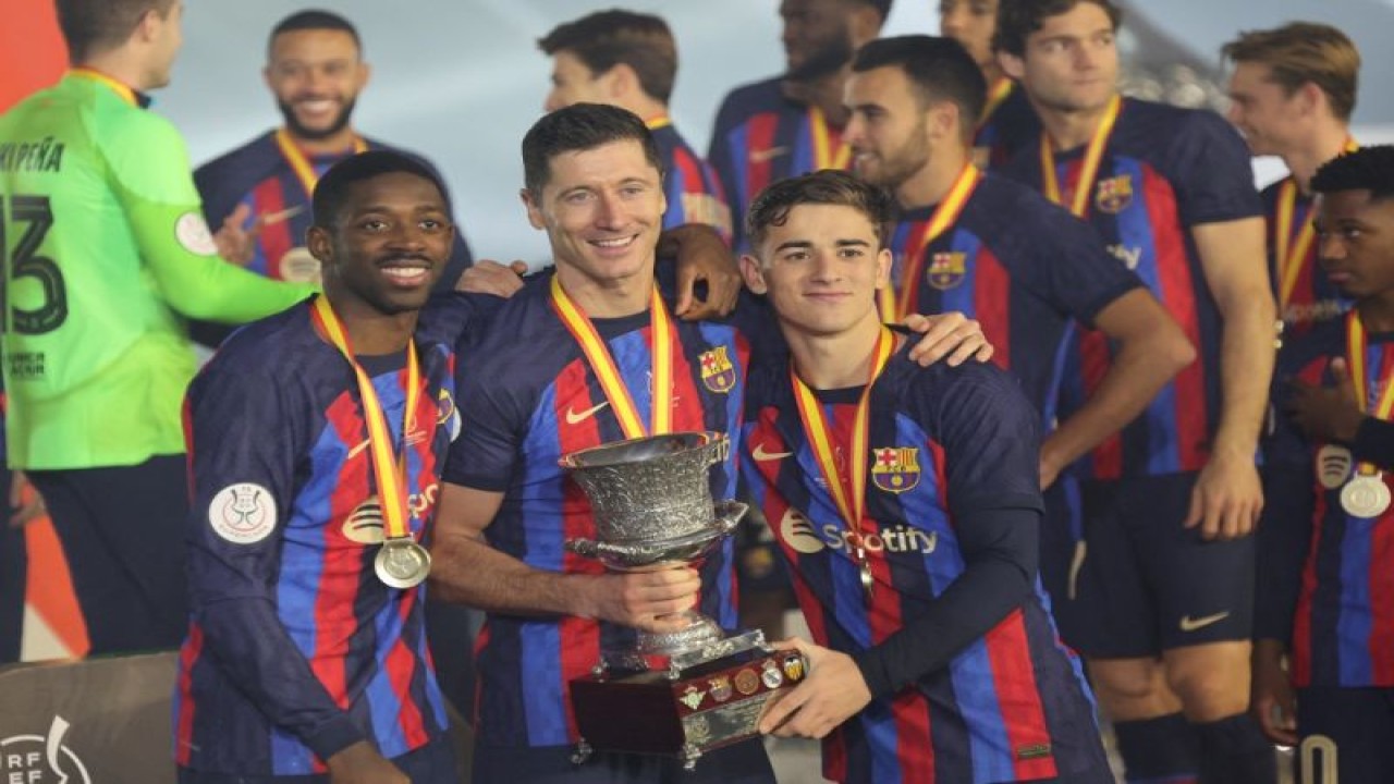 Pemain Barcelona Ousmane Dembele, Robert Lewandowski dan Gavi berpose dengan trofi Piala Super Spanyol setelah menang atas Real Madrid di Riyadh Arab Saudi 15 Januari 2023. (ANTARA/AFP/GIUSEPPE CACACE)