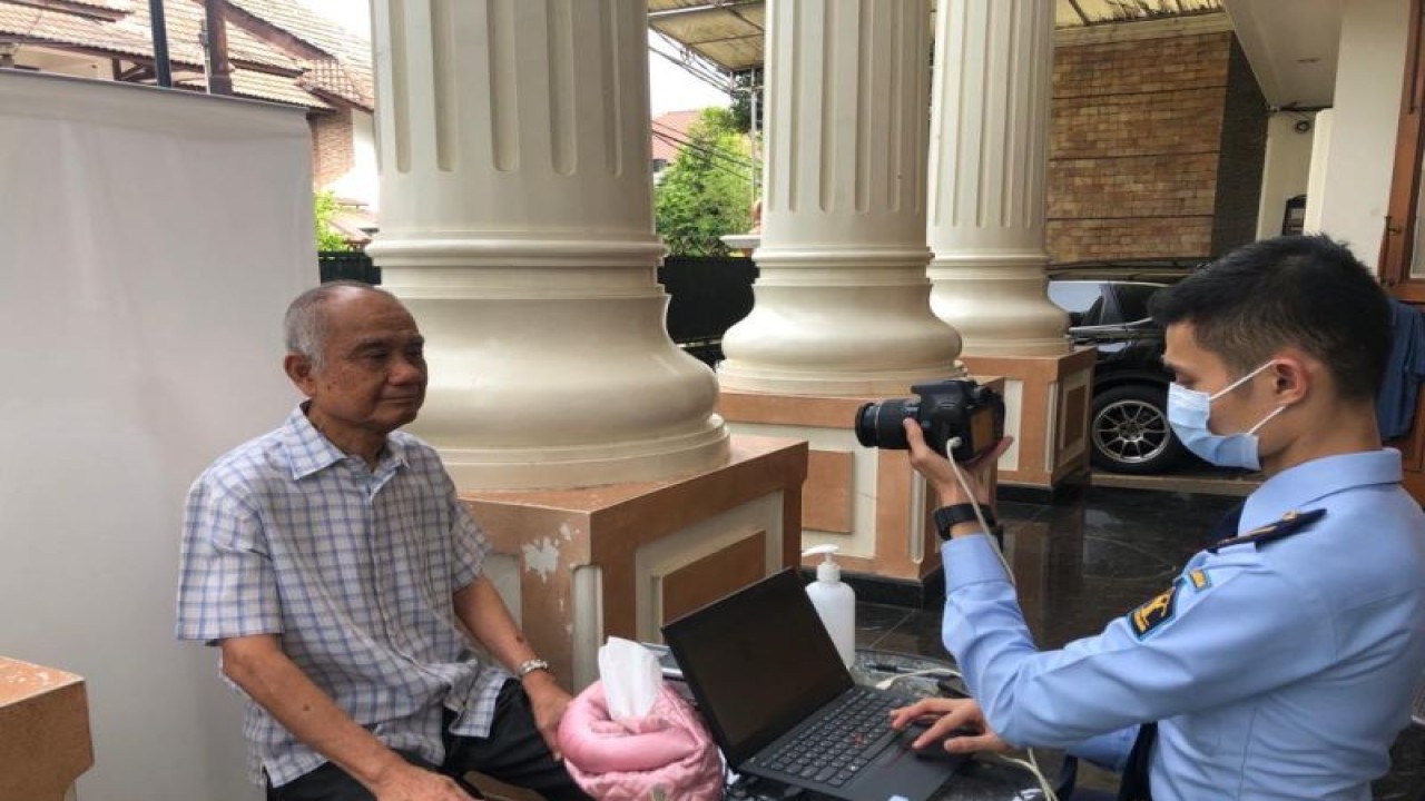 Pegawai Kantor Imigrasi Kelas I TPI Tanjung Priok melayani pengambilan foto dan biometrik pemohon paspor layanan I'Prima kategori lanjut usia (lansia) di rumah pemohon kawasan Jakarta Utara, Selasa (7/6/2022). (ANTARA/ HO-Humas Imigrasi Tanjung Priok)