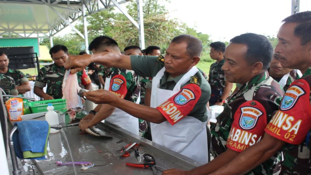 Kasdim 1016/Plk Letkol Abdul Salim (tiga kanan) mencontohkan cara membersihkan sisik ikan gabung kepada babinsa di Palangka Raya, Rabu (18/1/2023). (ANTARA/HO-Pendim 1016/Plk.)