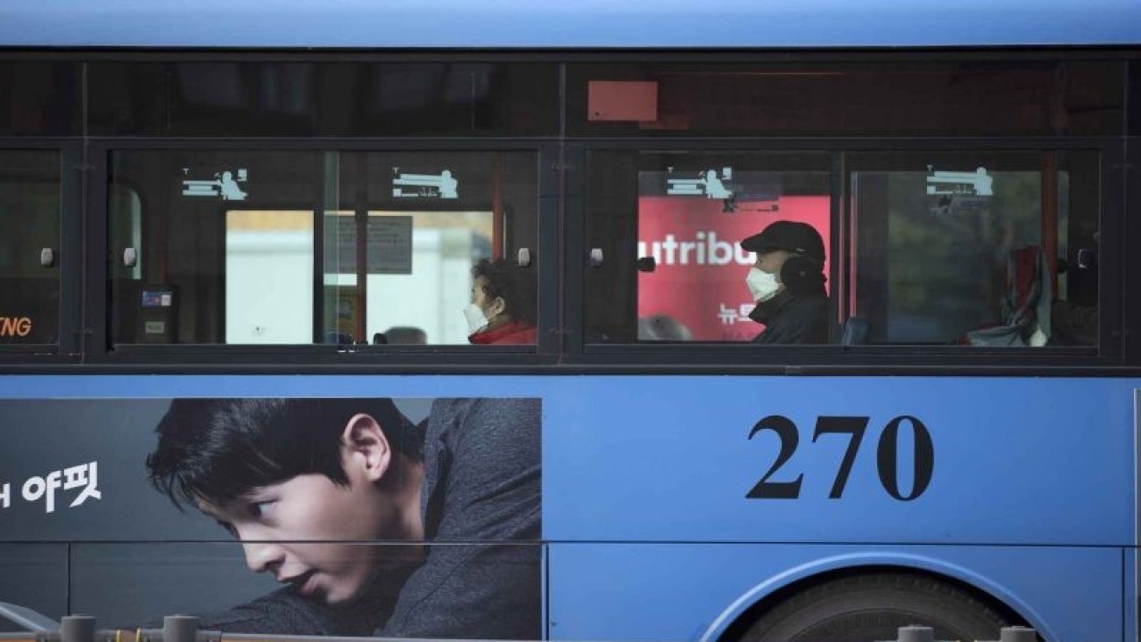 Penumpang yang mengenakan masker duduk di dalam sebuah bus di Seoul, Korea Selatan, Selasa (18/1/ 2022). ANTARA FOTO/Xinhua/Wang Yiliang/wsj.