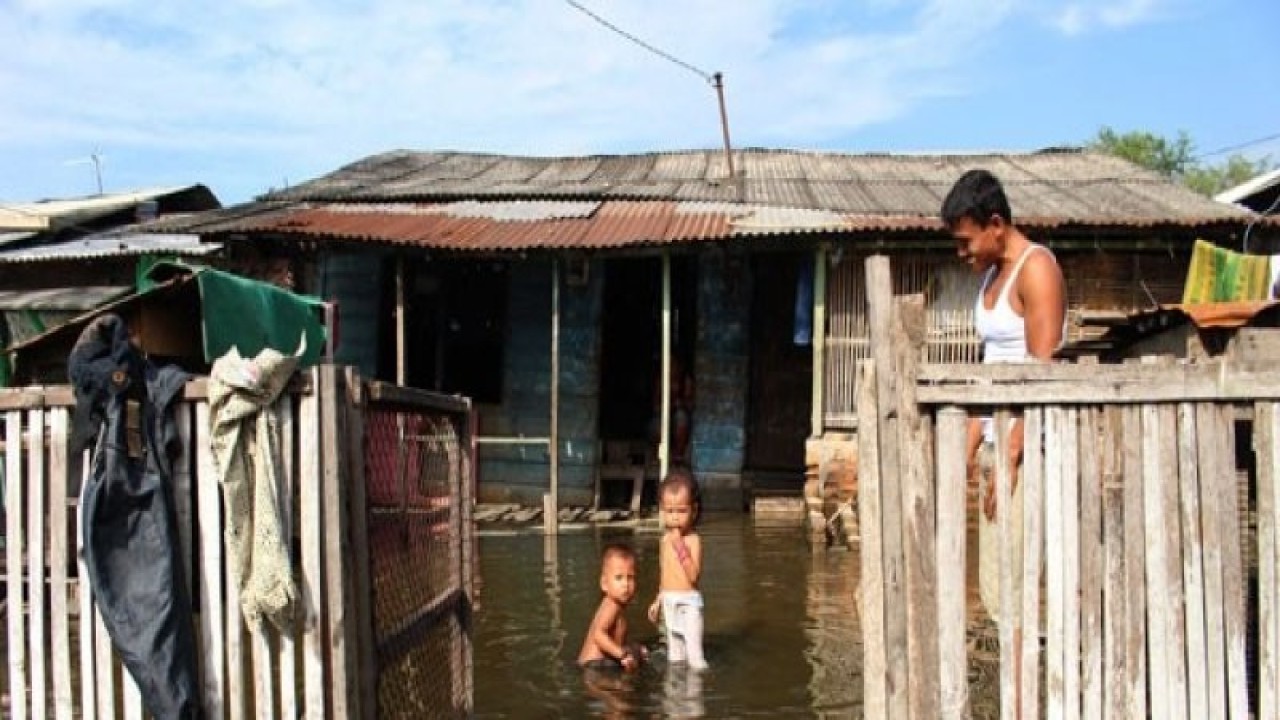 Ilustrasi: Banjir Rob Di Medan Seorang warga mengawasi anaknya yang bermain di sekitar genangan banjir rob (air laut pasang) di Belawan, Medan, Sumatera Utara, Rabu (8/6/2016). Genangan air setinggi 50 cm yang merendam sejumlah rumah di kawasan itu disebabkan air laut pasang yang menggenangi daratan. (ANTARA FOTO/Septianda Perdana)