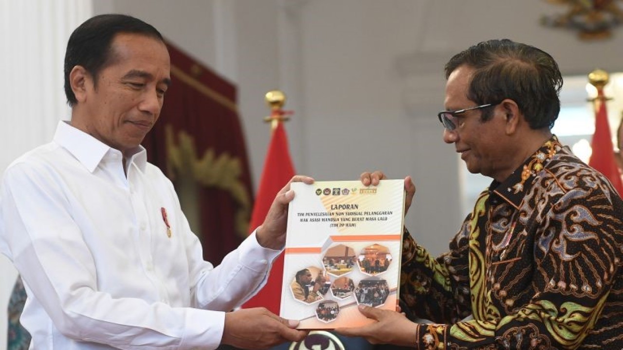 Presiden Joko Widodo (kiri) menerima laporan terkait pelanggaran HAM masa lalu dari Ketua Dewan Pengarah Tim Penyelesaian Non-Yudisial Pelanggaran HAM Berat Masa Lalu Mahfud MD (kanan) di Istana Merdeka, Jakarta, Rabu (11/1/2023). Pemerintah Indonesia mengakui terjadinya 12 pelanggaran HAM berat di masa lalu dan akan memulihkan hak-hak korban secara adil dan bijaksana tanpa menegasikan penyelesaian yudisial. ANTARA FOTO/Akbar Nugroho Gumay/foc.