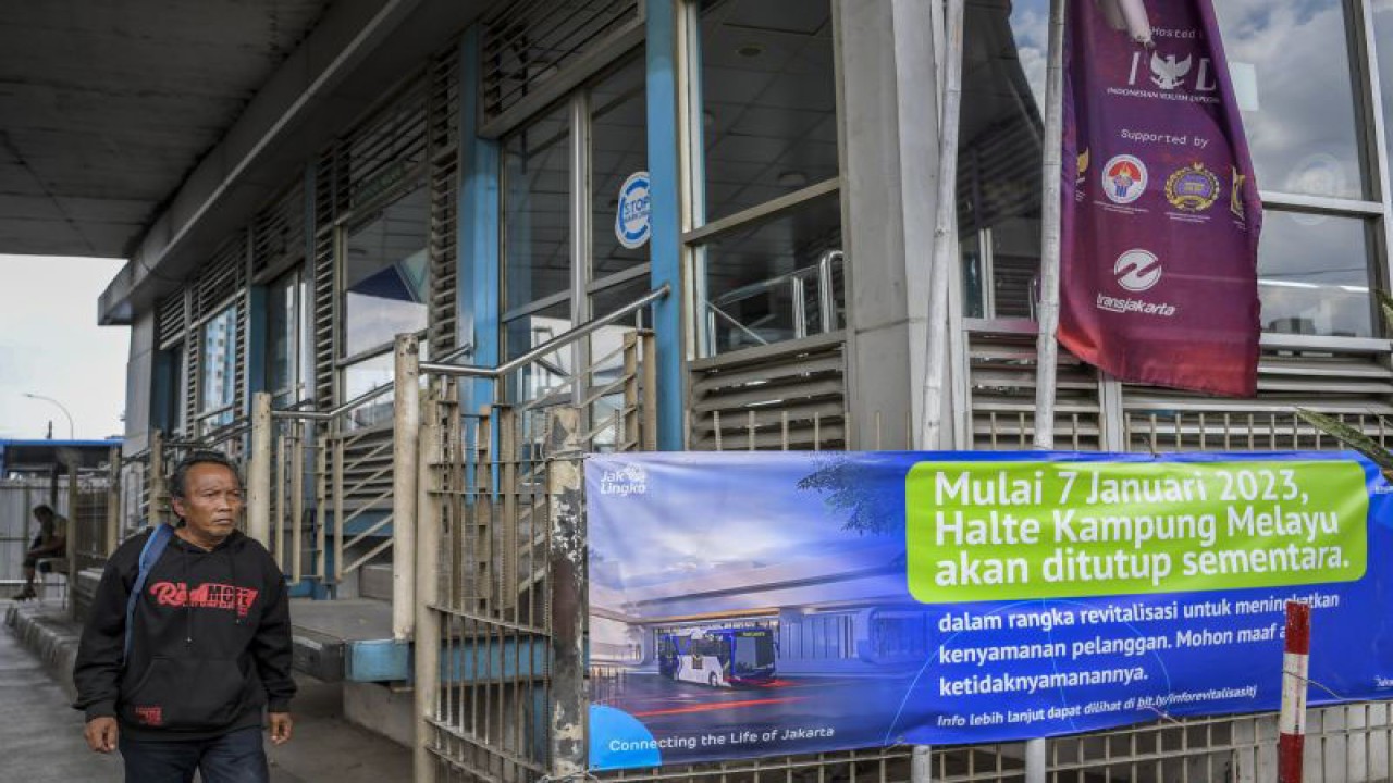 Warga melintas di depan Halte TransJakarta Kampung Melayu yang ditutup untuk direvitalisasi, di Jakarta, Senin (9/1/2023). PT TransJakarta menutup sementara Halte TransJakarta Kampung Melayu untuk proses konstruksi revitalisasi halte dan menargetkan pada akhir 2023 ada 72 halte yang telah direvitalisasi dari kurang lebih 200 halte. ANTARA FOTO/Galih Pradipta/tom.