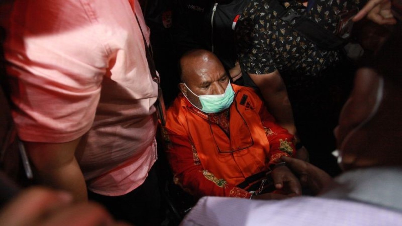 Tersangka Gubernur Papua Lukas Enembe (tengah) yang duduk di kursi roda dikawal petugas menuju mobil tahanan usai menjalani pemeriksaan di Gedung Merah Putih KPK, Jakarta, Kamis (12/1/2023). ANTARA FOTO/Reno Esnir/aww.