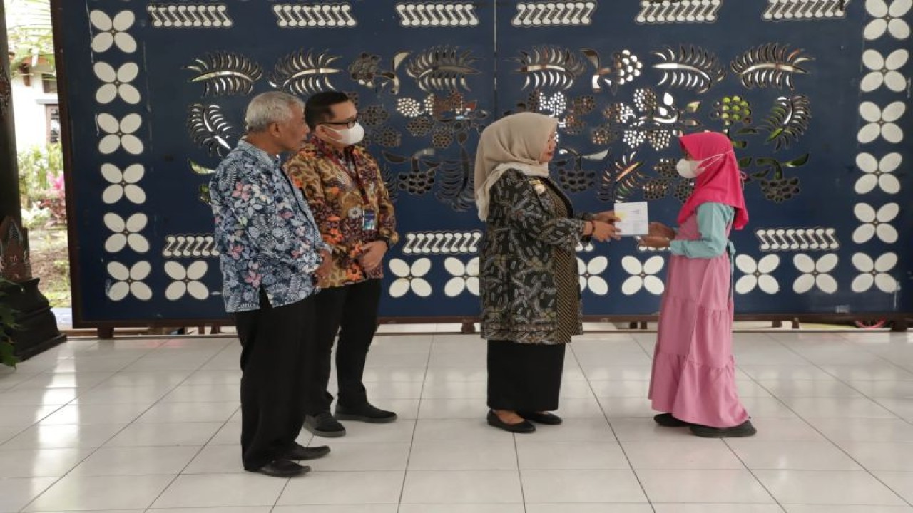 Bupati Sleman Kustini Sri Purnomo secara simbolis menyerahkan bantuan sosial untuk anak yatim piatu di Pendopo Rumah Dinas Bupati Sleman, Selasa (31/1/2023). (ANTARA/HO-Bagian Prokopim Setda Sleman)