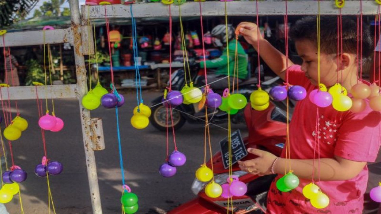 Seorang anak mencoba permainan lato-lato yang dijual di Cibinong, Kabupaten Bogor, Jawa Barat, Jumat (6/1/2023). (ANTARA FOTO/Yulius Satria Wijaya/aww).
