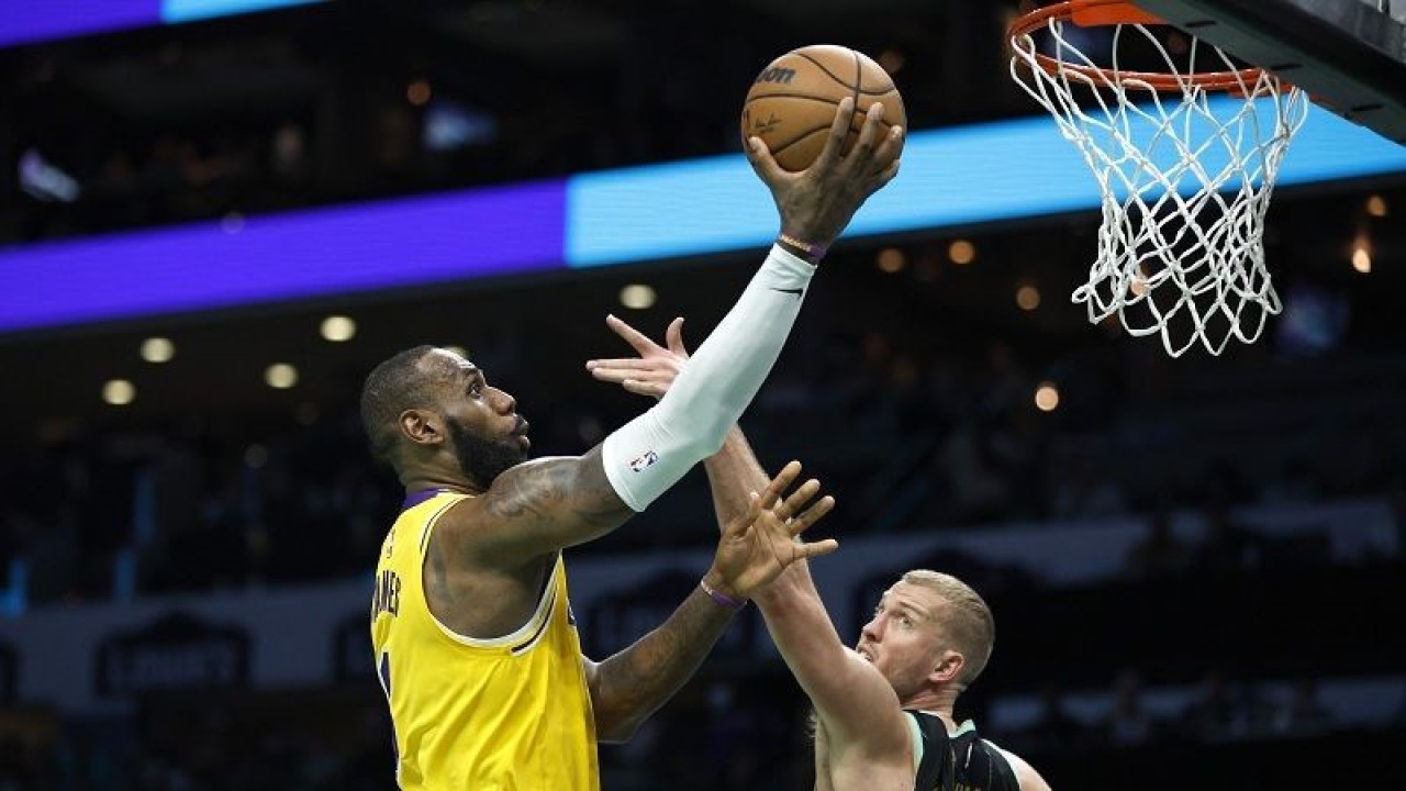 Megabintang Los Angeles Lakers LeBron James (kiri) melewati hadangan pemain Charlotte Hornets Mason Plumlee untuk mencetak angka dalam gim lanjutan NBA di Spectrum Center, Carolina Utara, Amerika Serikat, Senin (2/1/2023) waktu setempat. (ANTARA/AFP/GETTY IMAGES/Jared C. Tilton)