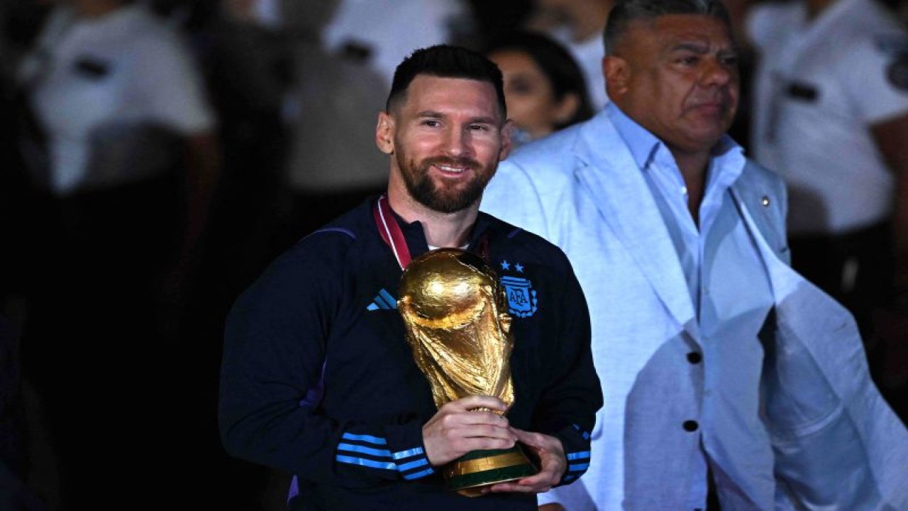 Lionel Messi memegang Tropi Piala Dunia FIFA saat tiba di Bandara Ezeiza International, Buenos Aires, Argentina pada 20 Desember 2022. ANTARA/AFP/LUIS ROBAYO.