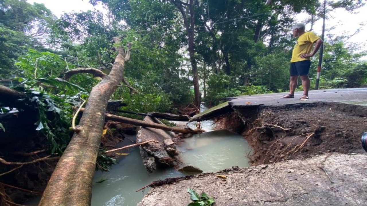 Seorang turis asing melihat jalan menuju wisata tugu kilometer nol Indonesia yang terputus akibat tanah longsor di kawasan Iboih, Kota Sabang, Aceh, Senin (30/1/2023). (ANTARA/Khalis Surry)