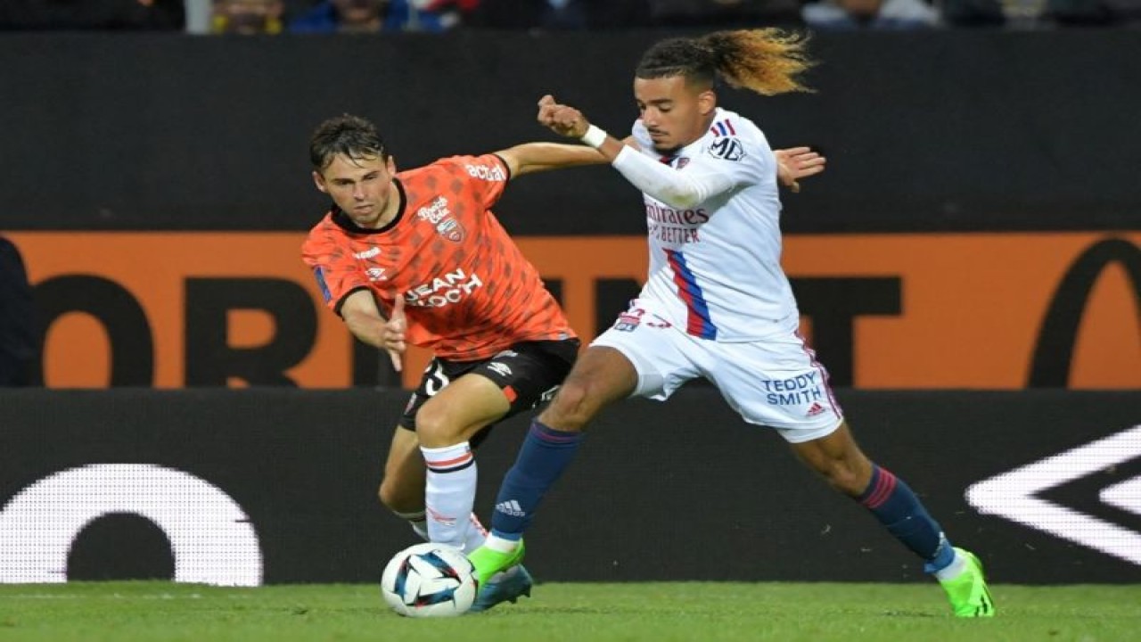Bek Lyon Malo Gusto (kanan) saat berduel dengan gelandang Lorient Theo Le Bris dalam pertandingan Ligue 1 Prancis antara Lorient dan Lyon di Stade du Moustoir di Lorient pada 7 September 2022. (AFP/JEAN-FRANCOIS MONIER)