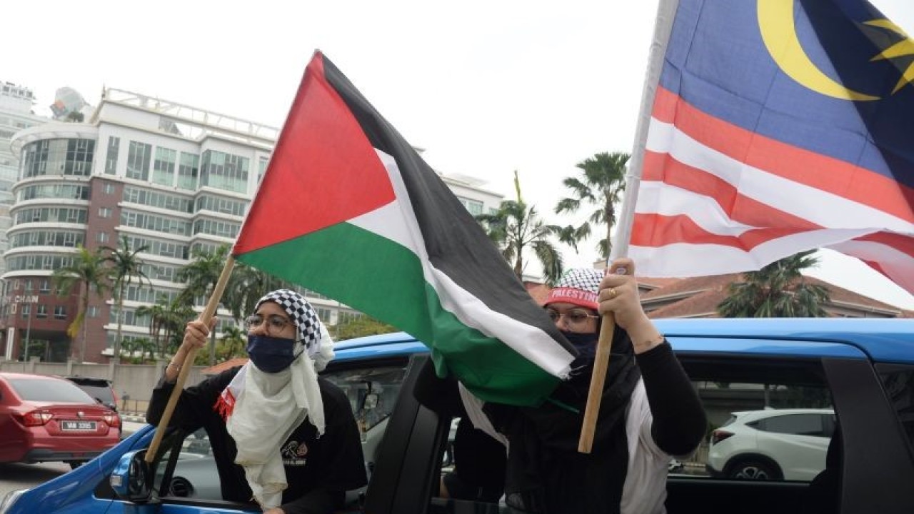 Arsip - Para pengunjuk rasa yang tergabung dalam Pemuda Pakatan Harapan mengibarkan bendera Palestina dan Malaysia saat aksi damai solidaritas mendukung Palestina di depan Kedutaan Besar Amerika Serikat di Kuala Lumpur, Malaysia, Jumat (21/5/2021). ANTARA FOTO/Rafiuddin Abdul Rahman/rwa.