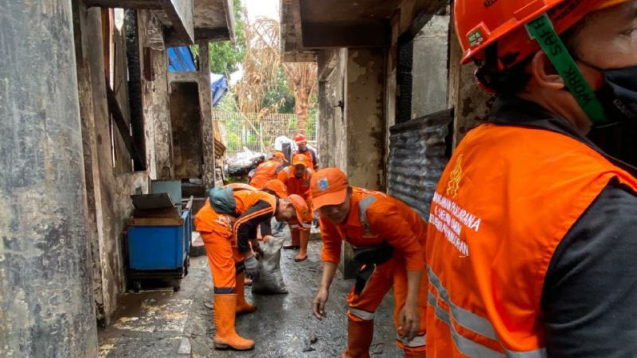 Sejumlah petugas PPSU membantu membersihkan sisa bangunan kebakaran Mampang, Jakarta, Jumat (6/1/2023). ANTARA/Luthfia Miranda Putri