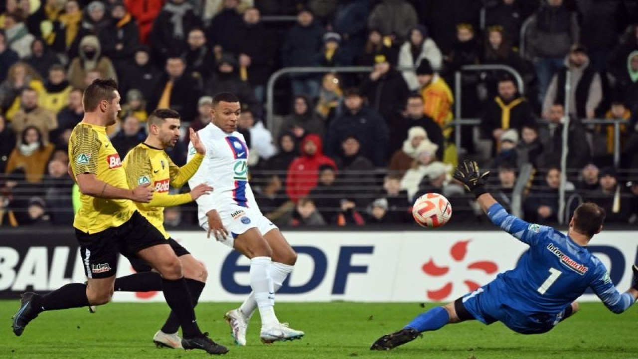Penyerang PSG Kylian Mbappe (kaus putih) mencetak gol ke gawang Pays de Cassel pada pertandingan 32 besar Piala Prancis 2023 yang dimainkan di Stade Bollaert-Delelis, Lens, Selasa (24/1/2023) WIB. (ANTARA/AFP/Francois LO PRESTI)