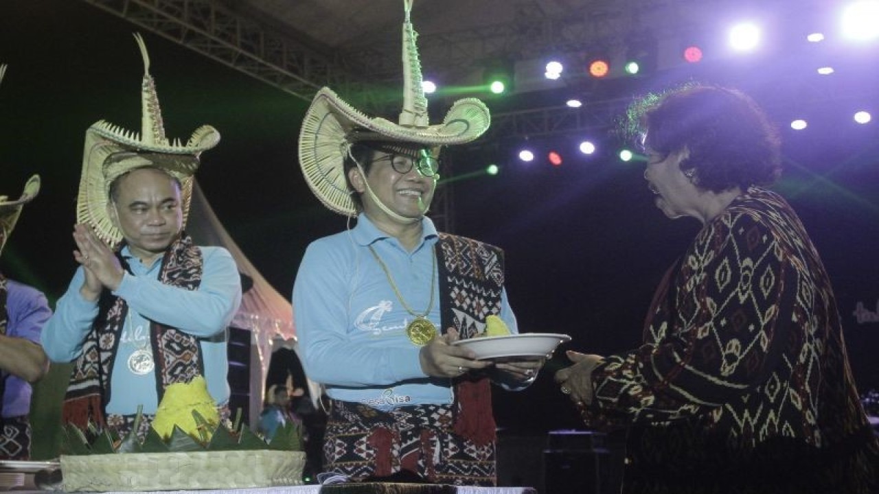 Menteri Desa PDTT Abdul Halim Iskandar memberikan potongan tumpeng kepada BupatI Rote Ndao Paulina Haning pada acara puncak peringatan 9 Tahun UU Desa di Kota Ba'a, Kabupaten Rote Ndao, Sabtu (14/1/2023). ANTARA/Kornelis Kaha