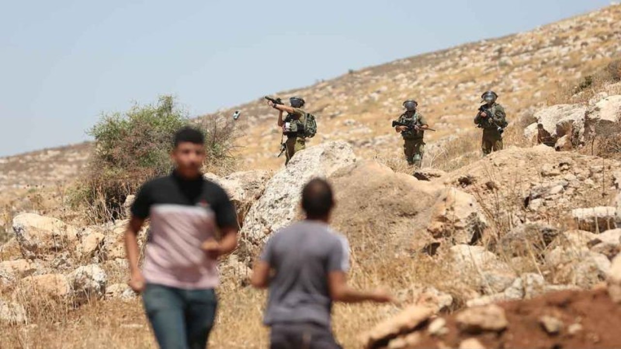 Seorang tentara Israel menembakkan tabung gas air mata ke arah sejumlah pengunjuk rasa Palestina dalam bentrokan di Desa Beit Dajan, sebelah timur Nablus, Tepi Barat, Jumat (29/7/2022). Unjuk rasa tersebut dilakukan untuk menentang perluasan permukiman Yahudi di kawasan itu. ANTARA FOTO/Xinhua/Ayman Nobani/rwa.