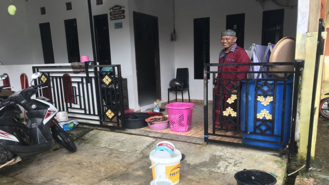 Warga di Perumahan Bukit Raya, Batam,  Provinsi Kepri, Muchtar sedang mencuci baju di halaman rumahnya menggunakan air hujan karena suplai air bersih tidak mengalir selama empat hari di perumahan itu, Senin (23/1/2023). (FOTO ANTARA/Yude)