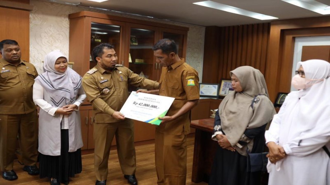 Ilustrasi - Pj Bupati Aceh Besar, Muhammad Iswanto didampingi Sekdakab Aceh Besar, Kepala BPJS Ketenagakerjaan Kantor Cabang Banda Aceh, menyerahkan santunan jaminan kematian kepada empat ahli waris peserta BPJS Ketenagakerjaan di Ruang Kerja Bupati Aceh Besar, Senin (ANTARA/HO)