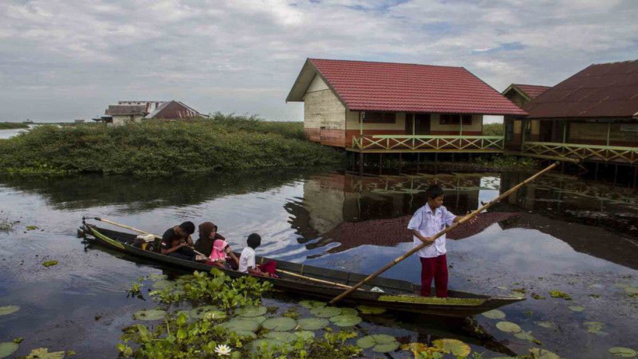 Murid menggunakan perahu saat menuju ke SD Negeri 3 Sungai Buluh di Kecamatan Labuan Amas Utara, Kabupaten Hulu Sungai Tengah, Kalimantan Selatan, Selasa (12/7/2022). Sekolah yang menampung 29 murid tingkat dasar yang berada di tengah-tengah rawa itu merupakan sekolah satu-satunya di dusun Awang Landas, jalur sungai menjadi satu-satunya jalur yang digunakan oleh guru dan muridnya untuk menuju sekolah tersebut karena tidak ada akses jalan darat. ANTARA FOTO/Bayu Pratama S/hp. (ANTARA FOTO/BAYU PRATAMA S)