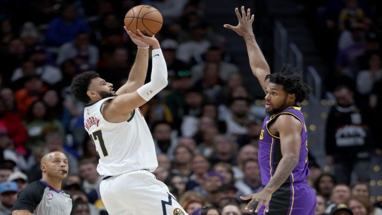 Pemain Denver Nuggets Jamal Muray memasukkan bola di tengah hadangan pemain LA Lakers Sterling Brown di Ball Arena, Denver, Colorado, 9 Januari 2023. (Getty Images via AFP/MATTHEW STOCKMAN)
