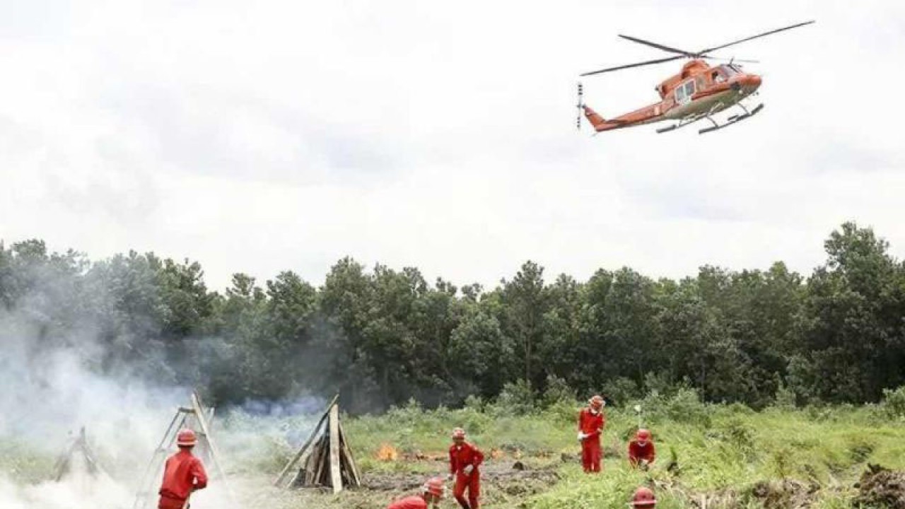 Tim Reaksi Cepat (TRC) Asia Pulp & Paper (APP) Sinar Mas dibantu helikopter Bell 412 melakukan simulasi pemadaman kebakaran lahan di Sungai Baung, Ogan Komering Ilir (OKI), Sumatera Selatan, Senin (14/5/2018). (ANTARA/Nova Wahyudi)