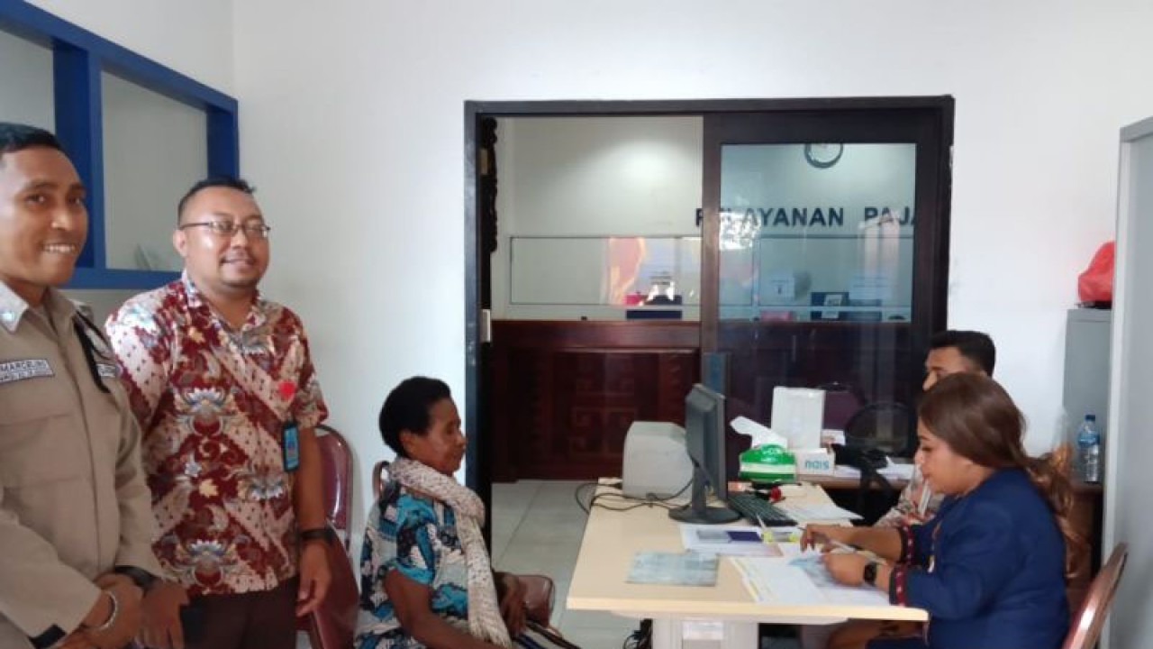 Seorang ibu lanjut usia menerima bantuan di Bank Papua Kantor Cabang Utama Manokwari, Kamis (12/1/2023) didampingi Kepala Bidang Rehabilitasi Sosial, Dinsos Manokwari Ferdy M. Lalenoh (dua dari kiri). (ANTARA/Rachmat Julaini)