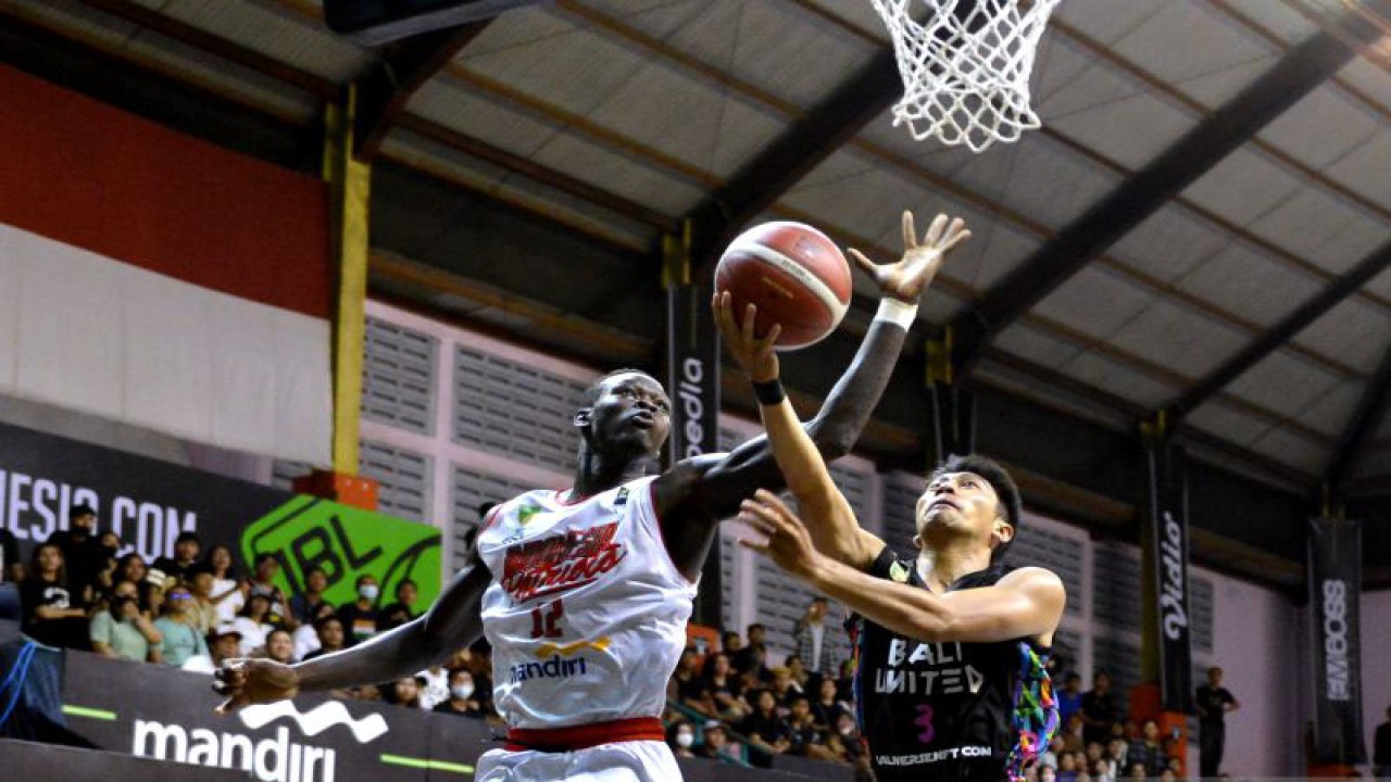 Pebasket Indonesia Patriots Dame Diagne (kiri) mencoba menghadang pebasket Bali United Basketball Handri Satrya Santosa (kanan) dalam pertandingan Indonesian Basketball League (IBL) 2023 di GOR Merpati, Denpasar, Bali, Senin (16/1/2023). ANTARA FOTO/Fikri Yusuf/tom.
