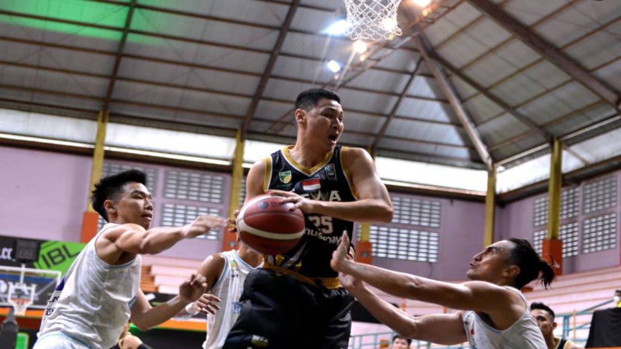 Pebasket Dewa United Banten Dio Tirta Saputra (tengah) berusaha melewati hadangan pebasket Evos Thunder Bogor Thomas Manuputty (kanan) dan William Rivaldi Kosasih (kiri) saat pertandingan Indonesian Basketball League (IBL) 2023 di GOR Merpati, Denpasar, Bali, Senin (16/1/2023). ANTARA FOTO/Fikri Yusuf/rwa. (ANTARA FOTO/FIKRI YUSUF)
