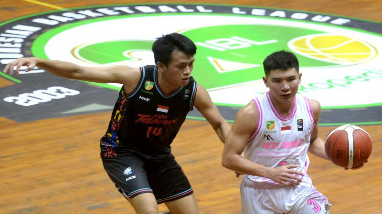 Pebasket West Bandits Solo Christian Gunawan (kanan) berebut bola dengan pebasket Evos Thunder Bogor Christopher Jason Winata (kiri) saat pertandingan Indonesian Basketball League (IBL) di GOR Merpati, Denpasar, Bali, Sabtu (14/1/2023). West Bandits Solo berhasil mengalahkan Evos Thunder Bogor dengan skor 54-50. ANTARA FOTO/Fikri Yusuf/YU (ANTARA FOTO/FIKRI YUSUF)