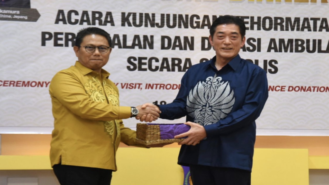 Penjagub Gorontalo Hamka Hendra Noer (kiri), menyerahkan cenderamata kepada Gubernur Prefektur Ehime, Tokihiro Nakamura. Keduanya mengenakan pakaian karawo, khas Gorontalo. ANTARA/HO-kominfo