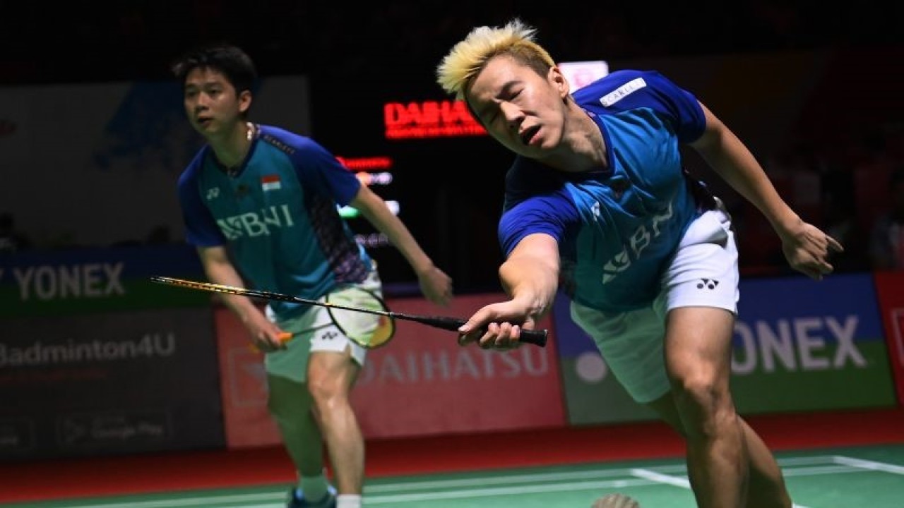 Pebulu tangkis ganda putra Indonesia Marcus Gideon (kanan) didampingi rekannya Kevin Sanjaya (kiri) gagal mengembalikan kok ke arah pebulu tangkis ganda putra China Liu Yu Chen dan Ou Xuan Yi dalam babak 16 besar turnamen Daihatsu Indonesia Masters 2023 di Istora Gelora Bung Karno, Jakarta, Kamis (26/1/2023). The Minions gagal lolos ke babak selanjutnya karena memutuskan untuk mundur atau retired di set ketiga akibat cedera yang dialami Marcus Gideon saat ganda China unggul dengan skor 19 - 21, 21-8 dan 11-6. ANTARA FOTO/Indrianto Eko Suwarso/hp.