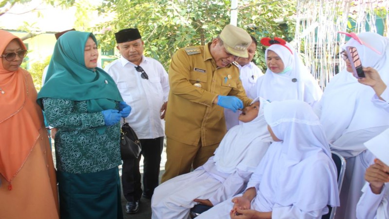 Pj Bupati Darmansah memberikan tablet tambah darah pada siswi sekolah MTsN di Manggeng, Aceh Barat Daya, Senin (30/1/2023). ANTARA/Suprian