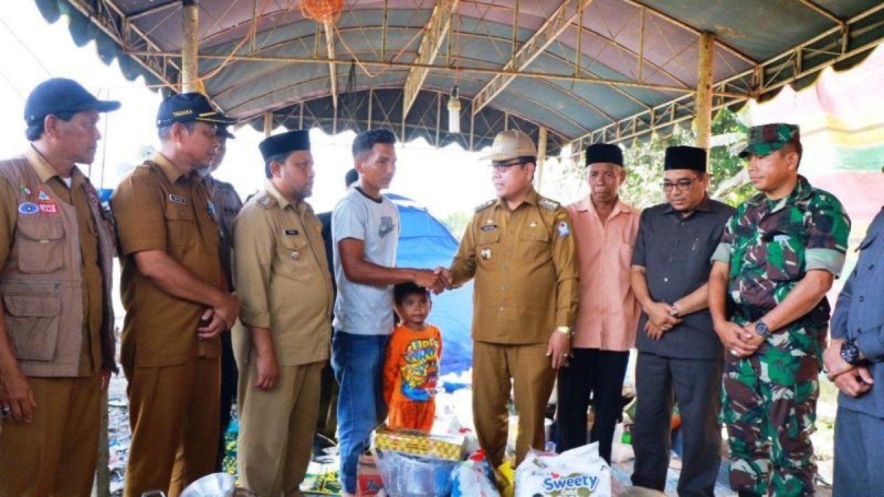 Pj Bupati Aceh Barat Mahdi didampingi sejumlah pejabat menyalurkan bantuan masa panik kepada seorang warga Desa Alue Perman, Kecamata Woyla Barat, Kabupaten Aceh Barat, yang mengalami musibah kebakaran, Kamis (12/1/2023). (ANTARA/HO-Dok Pemkab Aceh Barat)