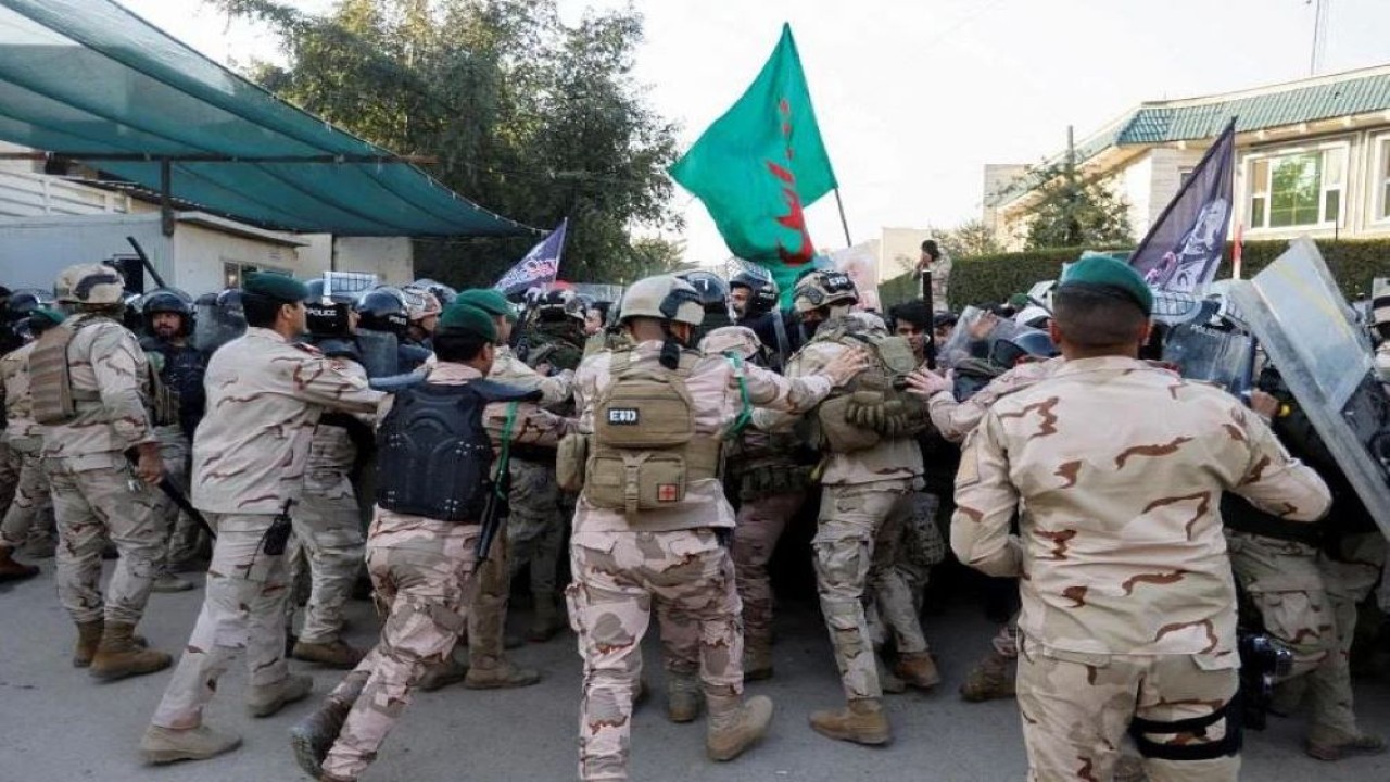 Pasukan keamanan Irak memukul mundur para pengunjuk rasa selama protes pembakaran Al-Qur'an di luar kedutaan Swedia di Baghdad, Irak, pada Senin, 23 Januari 2023. (Reuters)