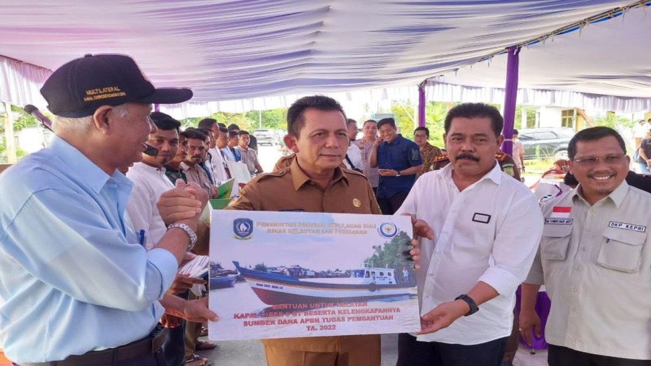Gubernur Kepri, Ansar Ahmad (tengah) saat menyerahkan bantuan kapal kepada Koperasi Nelayan Natuna di Kelarik, Bunguran Utara, Natuna, Selasa (10/1). (FOTO ANTARA/Cherman)