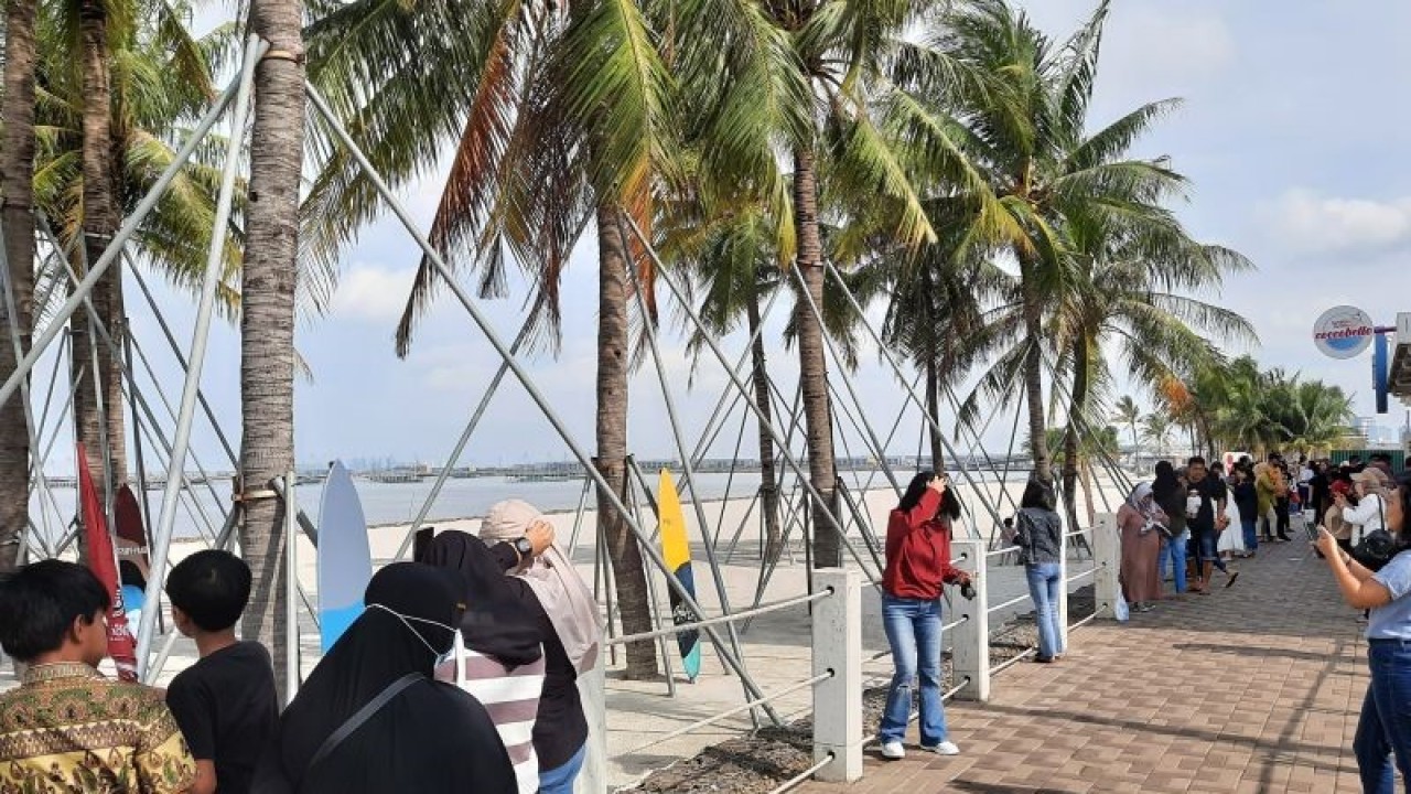 Pengunjung berfoto di area Pantai Pasir Putih, Pantai Indah Kapuk (PIK) 2, Dadap, Banten pada Minggu (1/1/2023). (ANTARA/Lia Wanadriani Santosa)