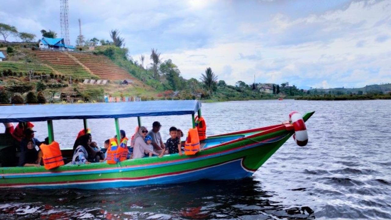 Pengunjung objek wisata Danau Mas Harun Bastari di Kabupaten Rejang Lebong, Bengkulu, berkeliling naik perahu menikmati pemandangan pada libur Tahun Baru 2023. ANTARA/Nur Muhamad