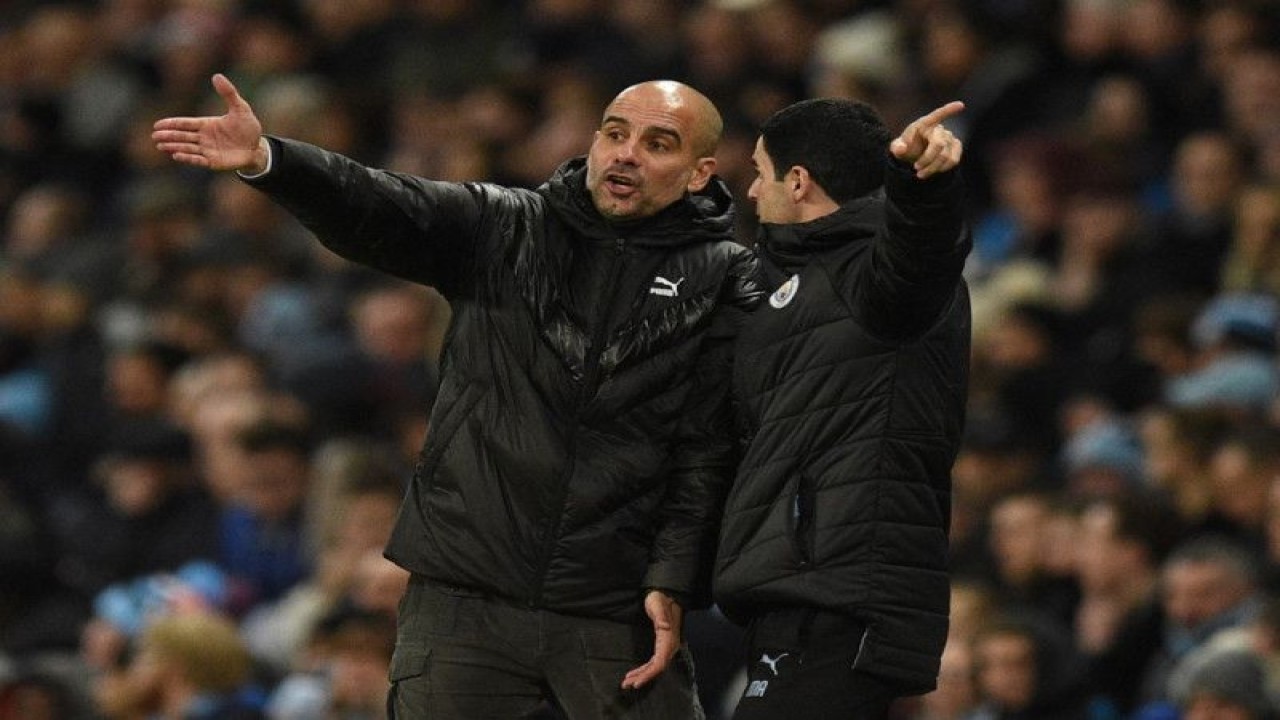 Pep Guardiola (kiri) dan Mikel Arteta saat masih bersama melatih Manchester City dalam pertandingan Liga Champions antara  Manchester City dan Shakhtar Donetsk di Stadion Etihad di Manchester pada 26 November 2019.  Kini kedua pelatih bersaing mengantarkan City dan Arsenal menjuarai Liga Inggris. (Photo by Oli SCARFF / AFP) (AFP/OLI SCARFF)