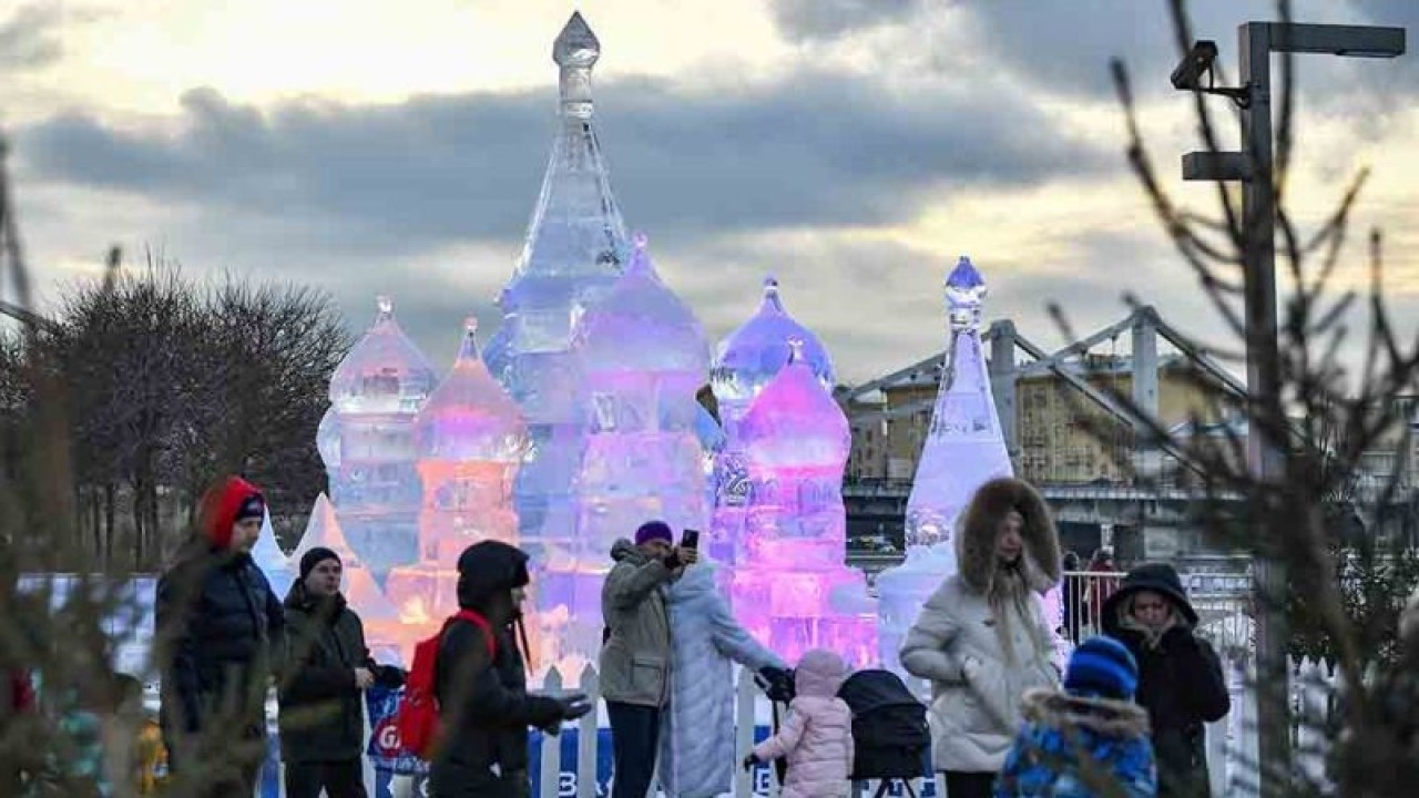 Pengunjung berswafoto dengan latar pahatan es saat pameran pahatan es di Moskow, Rusia, Kamis (5/1/2023). ANTARA FOTO/Xinhua/Alexander Zemlianichenko Jr/rwa.