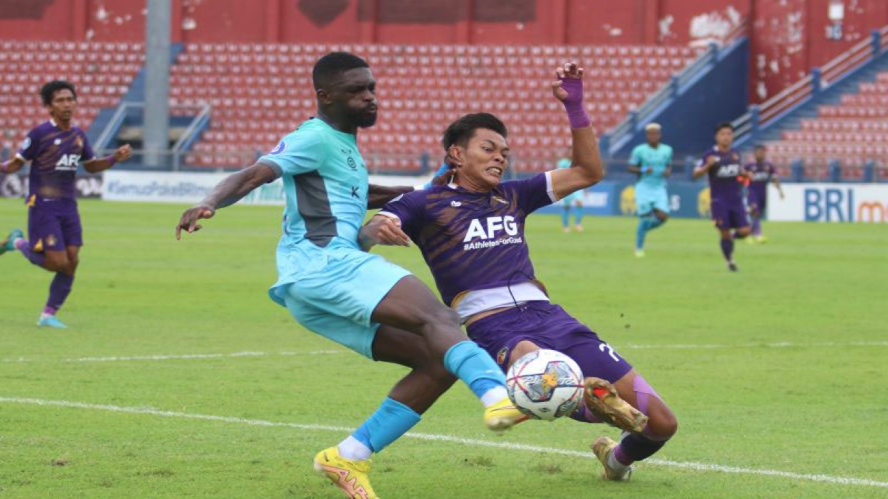 Pesepak bola Persik Kediri Yusuf Mulana (kanan) berebut bola dengan pemain Madura United FC Kwabena Appiah (kiri) pada pertandingan Liga 1 di Stadion Brawijaya, Kota Kediri, Jawa Timur, Selasa (24/1/2023). ANTARA FOTO/Prasetia Fauzani/aww.